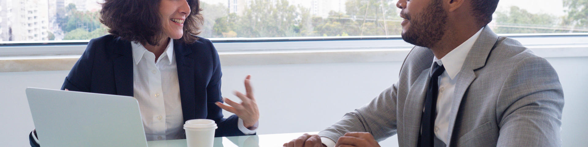 Two people talking at a desk